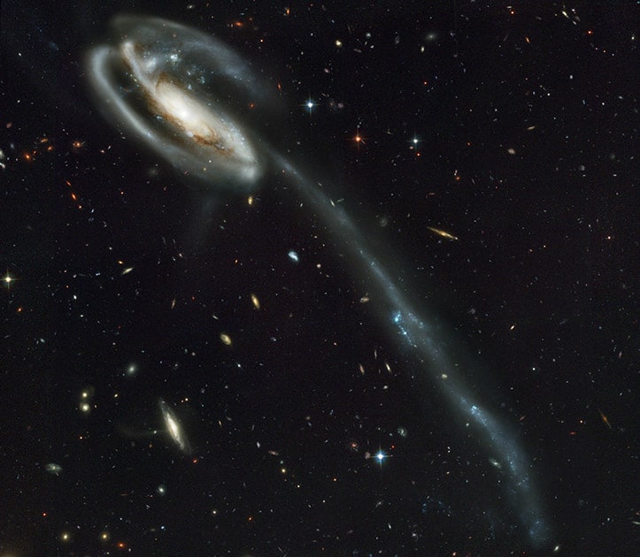 This image made by the NASA/ESA Hubble Space Telescope shows galaxy UGC 10214 with the long streamer of stars. Its distorted shape was caused by another galaxy passing nearby. The Hubble Space Telescope marks its 25th anniversary.