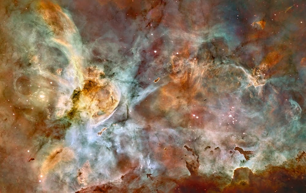 This false-color image made by the NASA/ESA Hubble Space Telescope shows the Carina Nebula. Outflowing winds and intense ultraviolet radiation from the large stars shape the material that is the last vestige of the giant cloud from which the stars were born. Red corresponds to sulfur, green to hydrogen, and blue to oxygen emission. The Hubble Space Telescope marks its 25th anniversary.