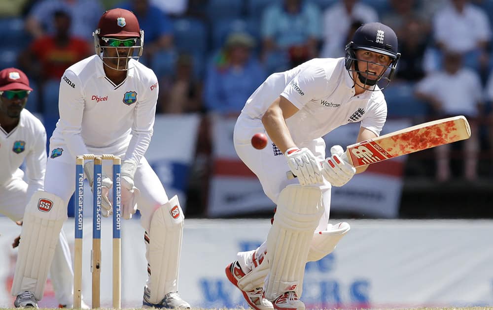 England's Gary Ballance, right, plays a delivery from West Indies' Marlon Samuels under the look of wicketkeeper Denesh Ramdin during the third day of their second Test match at the National Stadium in St. George's, Grenada.
