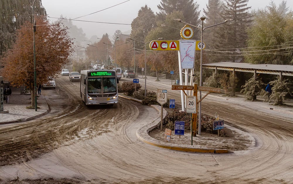 A bus drives along an ash covered road, caused by the eruption of Chile's Calbuco volcano in Villa La Angostura.