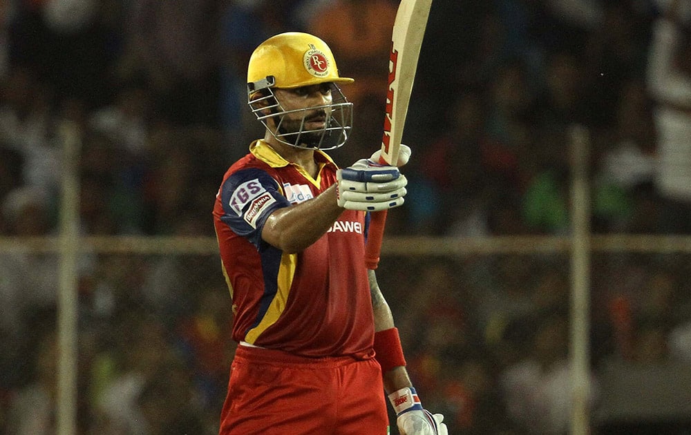 Royal Challengers Bangalore captain Virat Kohli raises his bat after scoring a fifty against Rajasthan Royals during an IPL match against in Ahmedabad.