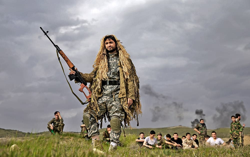 A member of the Iranian paramilitary Basij force, affiliated to the Revolutionary Guard, stands holding his gun during training in a Guard base in northeastern Tehran.