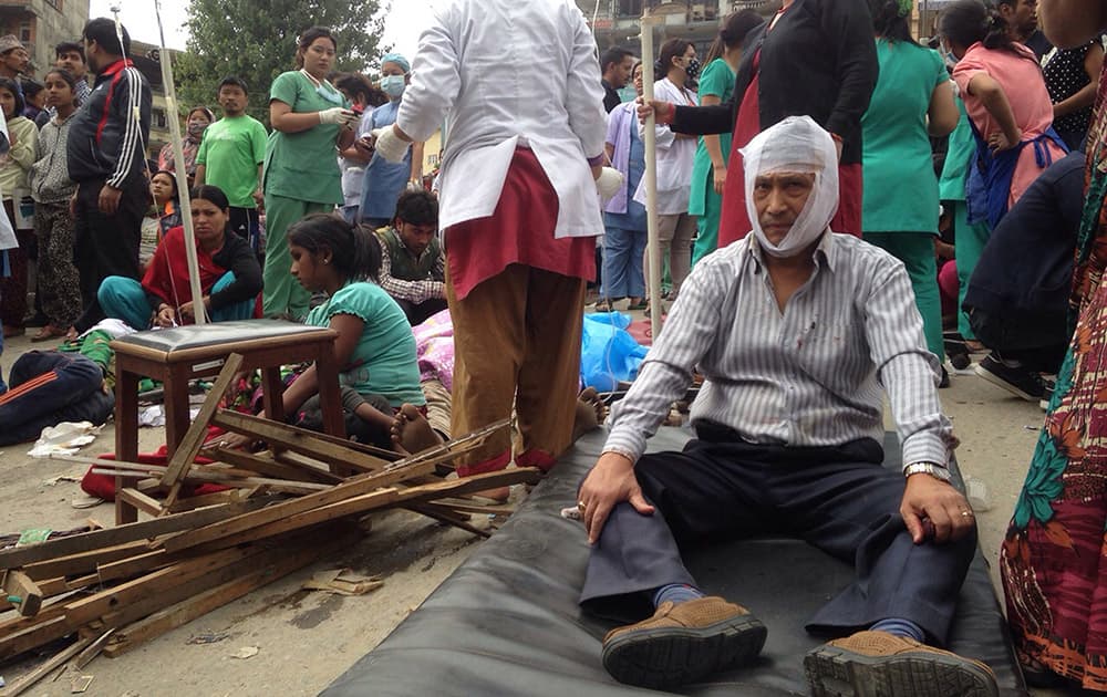 Injured people receive treatment outside the Medicare Hospital in Kathmandu, Nepal. A strong magnitude-7.9 earthquake shook Nepal's capital and the densely populated Kathmandu Valley before noon Saturday, causing extensive damage with toppled walls and collapsed buildings, officials said.