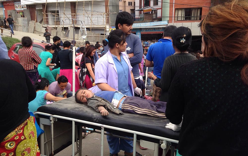 An injured child receives treatment outside Medicare Hospital in Kathmandu, Nepal. A strong magnitude-7.9 earthquake shook Nepal's capital and the densely populated Kathmandu Valley before noon Saturday, causing extensive damage with toppled walls and collapsed buildings, officials said. 