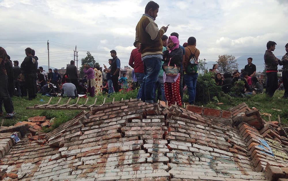A group of people gather outdoors as an earthquake hits Kathmandu city, Nepal. A strong magnitude-7.9 earthquake shook Nepal's capital and the densely populated Kathmandu Valley before noon Saturday, causing extensive damage with toppled walls and collapsed buildings, officials said.