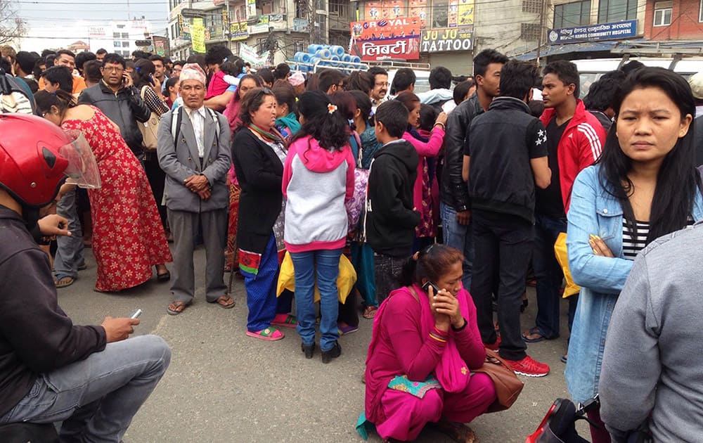 A group of people gather outdoors on a street as an earthquake hits Kathmandu city, Nepal. A strong magnitude-7.9 earthquake shook Nepal's capital and the densely populated Kathmandu Valley before noon Saturday, causing extensive damage with toppled walls and collapsed buildings, officials said.