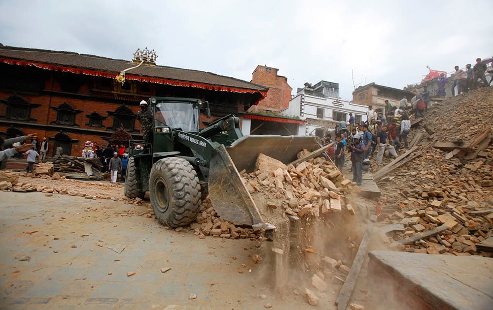 An earthmover removes debris at Durbar Square after an earthquake in Kathmandu, Nepal. A strong magnitude-7.9 earthquake shook Nepal's capital and the densely populated Kathmandu Valley before noon Saturday, causing extensive damage with toppled walls and collapsed buildings, officials said. 