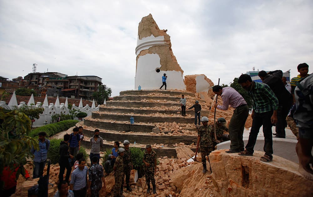 Volunteers work to remove debris at the historic Dharahara tower, a city landmark, after an earthquake in Kathmandu, Nepal. A strong magnitude-7.9 earthquake shook Nepal's capital and the densely populated Kathmandu Valley before noon Saturday, causing extensive damage with toppled walls and collapsed buildings, officials said.