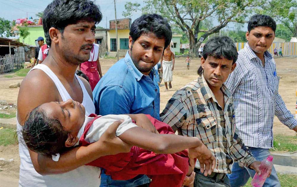 People carry a school girl toa hospital as she fainted after an earthquake in Malda district in West Bengal.