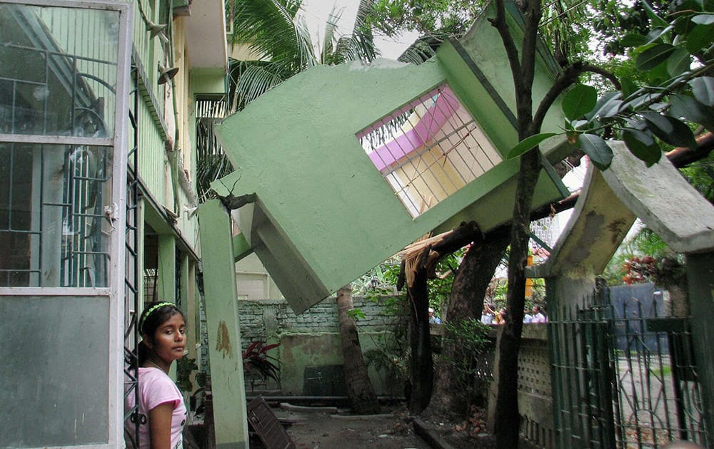 A portion of a residential building collapses following a tremor in Siliguri.