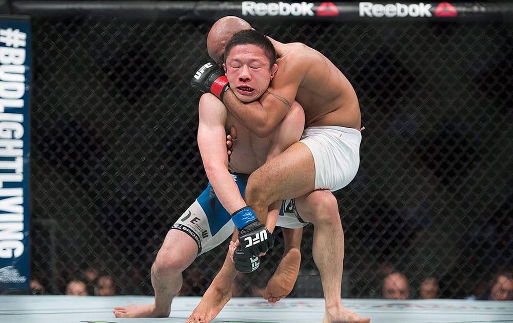 Demetrious Johnson, right, from the United States, takes Kyoji Horiguchi, from Japan, down during their UFC 186 mixed martial arts flyweight title fight in Montreal.