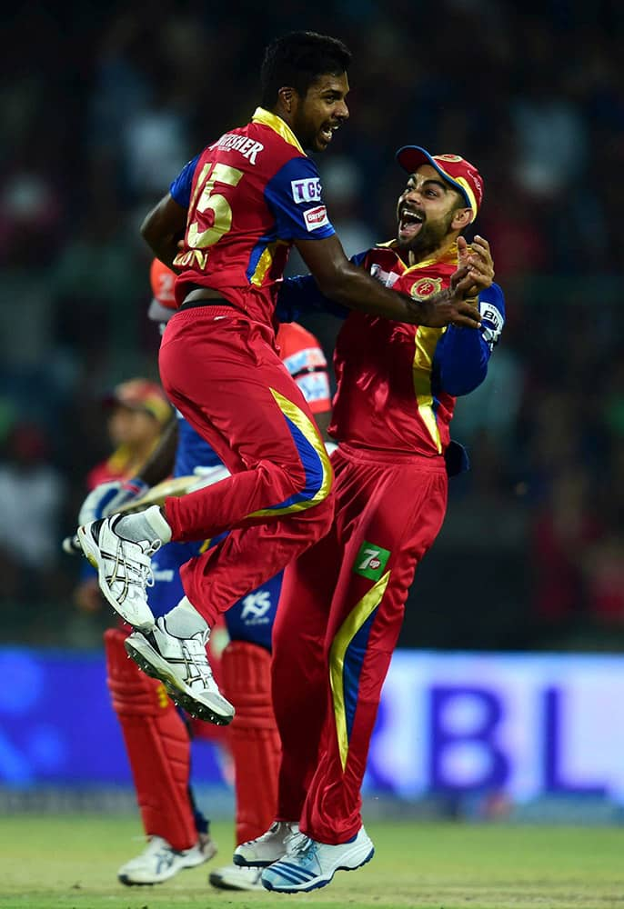 Royal Challengers Bangalore captain Virat Kohli and bowler Varun Aaron celebrate wicket of Delhi Daredevils batsman A Mathews during an IPL match at Feroz Shah Kotla Stadium in New Delhi.