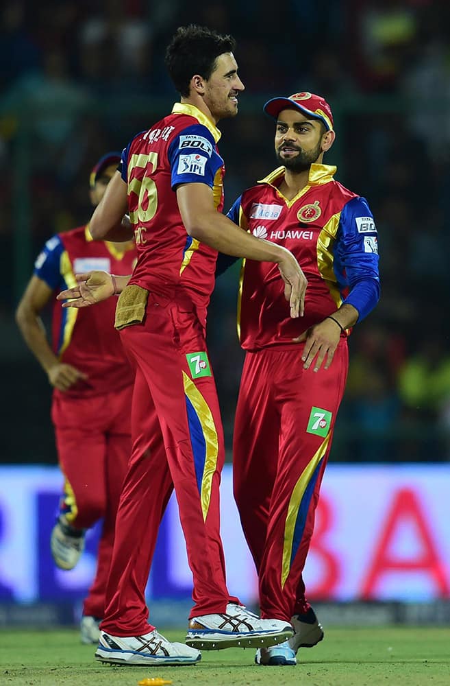 Royal Challengers Bangalore captain Virat Kohli and bowler Varun Aaron celebrate wicket of Delhi Daredevils batsman A Mathews during an IPL match at Feroz Shah Kotla Stadium in New Delhi.