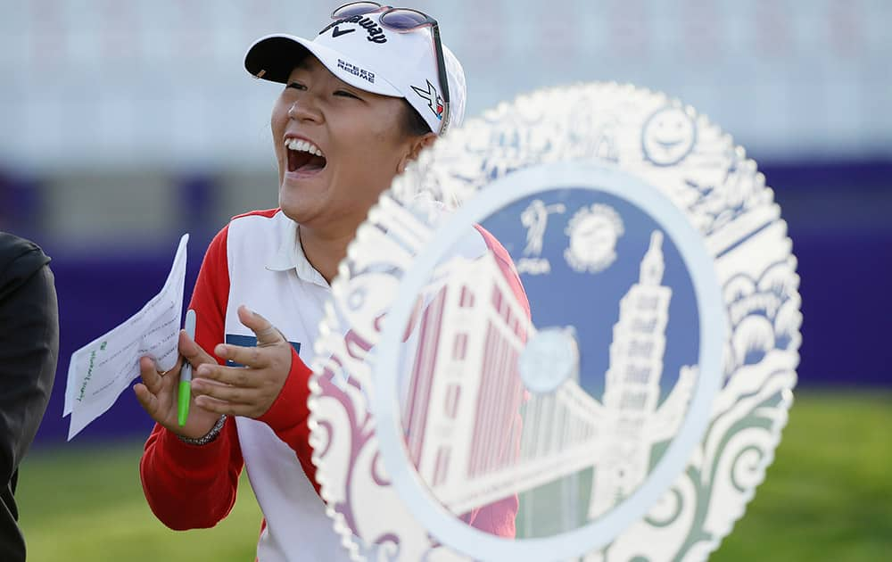 Lydia Ko of New Zealand laughs standing by her trophy after winning the Swinging Skirts LPGA Classic golf tournament, in Daly City, Calif.