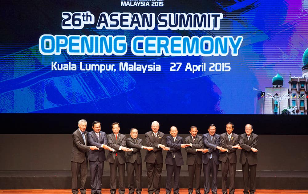 From left to right, Singapore's Prime Minister Lee Hsien Loong, Thailand's Prime Minister Prayuth Chan-ocha, Vietnam's Prime Minister Nguyen Tan Dung, Laos's Prime Minister Thongsing Thammavong, Malaysia's Prime Minister Najib Razak, Myanmar's President Thein Sein, Brunei's Sultan Hassanal Bolkiah, Cambodia's Prime Minister Hun Sen, Indonesia's President Joko Widodo, and Philippine's President Benigno Aquino III join their hands during the opening ceremony for the 26th ASEAN Summit in Kuala Lumpur, Malaysia.