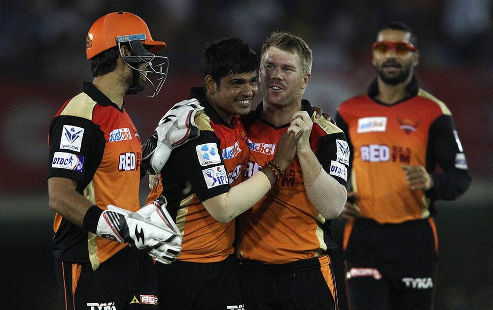 Sunrisers Hyderabads captain David Warner and Naman Ojha congratulate Karn Sharma after taking wicket of Kings XI Punjab during an IPL match in Mohali.