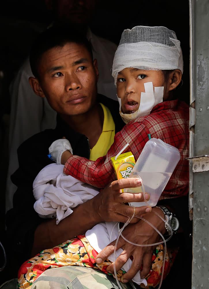 A child injured in Saturday’s earthquake, is carried by a Nepalese soldier after being evacuated as they wait to disembark from an Indian Air Force helicopter at the airport in Kathmandu, Nepal.