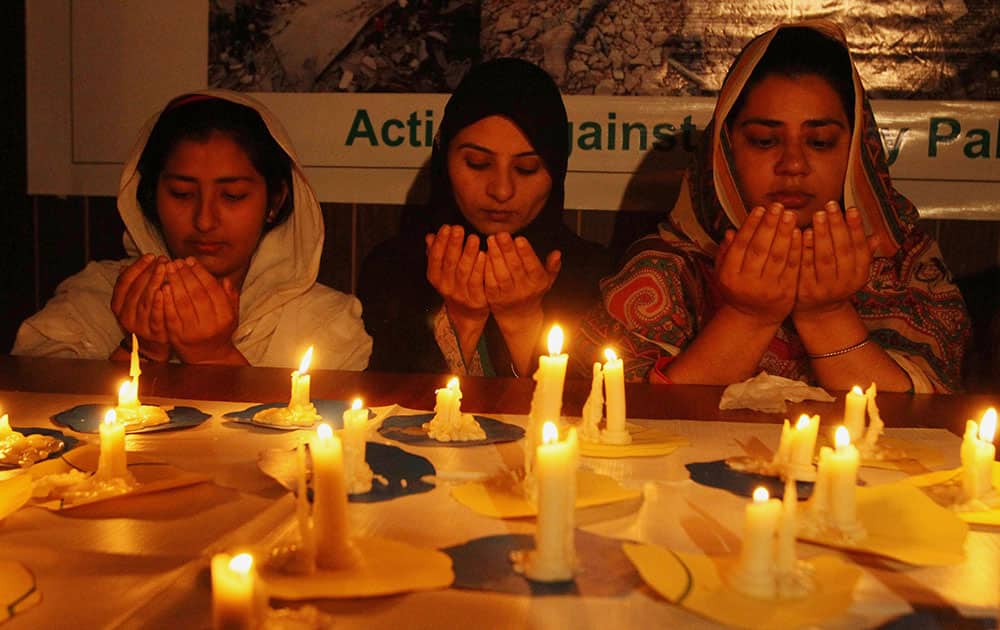 Pakistani girls light candles and offer prayers for Nepalese victims of Saturday's earthquake, in Multan, Pakistan.
