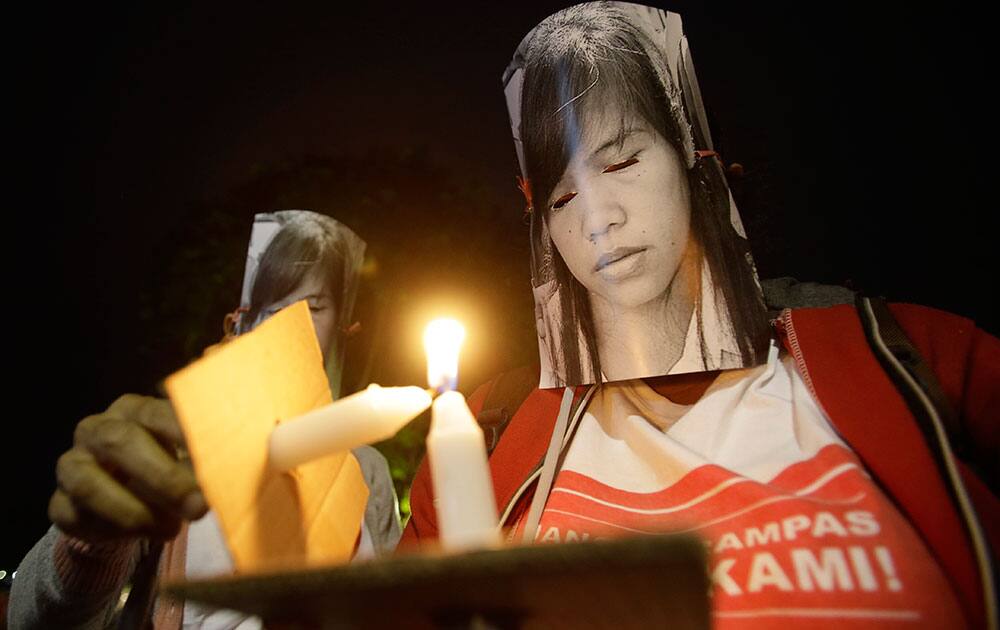 Indonesian protesters wearing masks of convicted Filipino Mary Jane Veloso attend a demonstration, demanding the government to stop the execution of her in Jakarta.