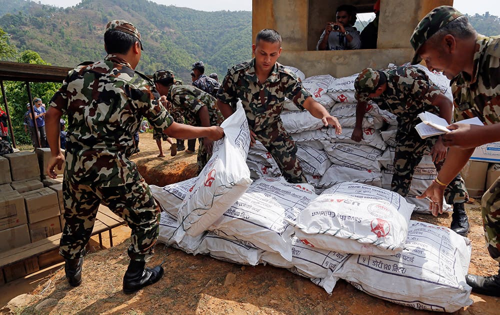Nepalese soldiers load U.S. AID relief sacks at landing zone near Saturday's massive earthquake's epicenter in the town of Gorkha, Nepal.