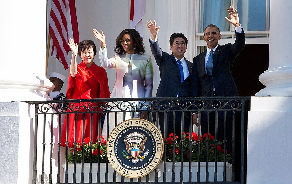 President Barack Obama and Japanese Prime Minister Shinzo Abe wave during a state arrival ceremony for the prime minister, at the White House in Washington.