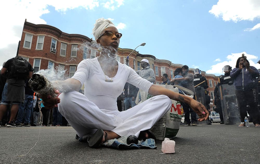 Shawna Murray-Browne sits in a street in Baltimore. Maryland's governor vowed there would be no repeat of the looting, arson and vandalism that erupted Monday in some of the city's poorest neighborhoods.