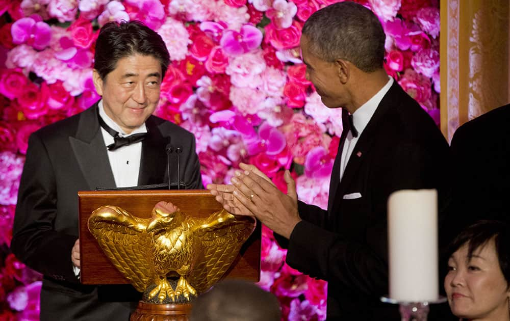 President Barack Obama introduces Japanese Prime Minister Shinzo Abe, left, as he host him and Abe's wife Akie Abe, right, at the State Dinner at the White House in Washington.