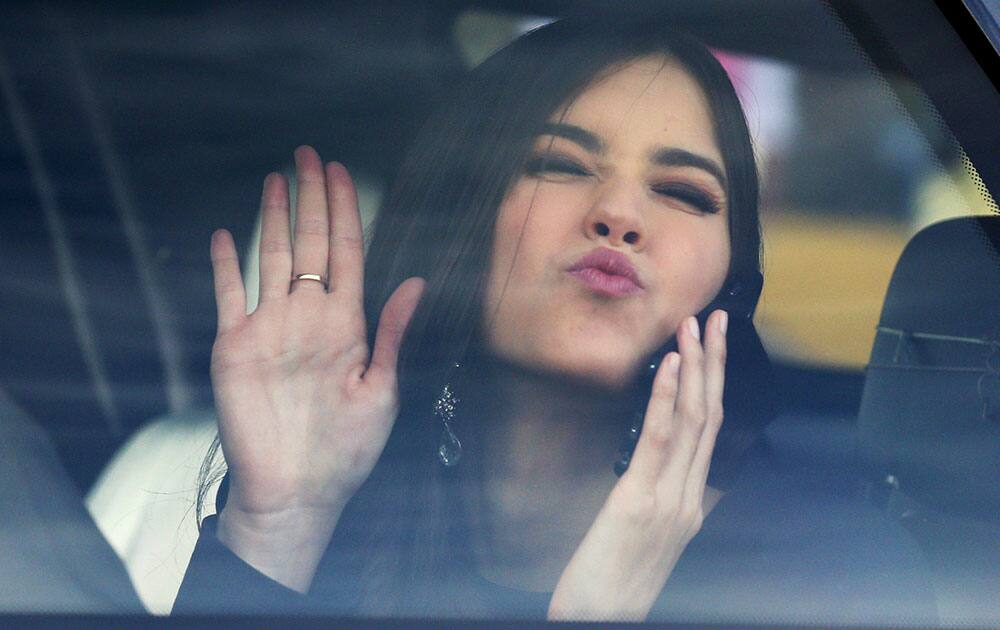 Miss Universe Paulina Vega, from Colombia, jokingly blows a kiss and waves to photographers from a car after visiting patients at a military hospital in Bogota, Colombia.