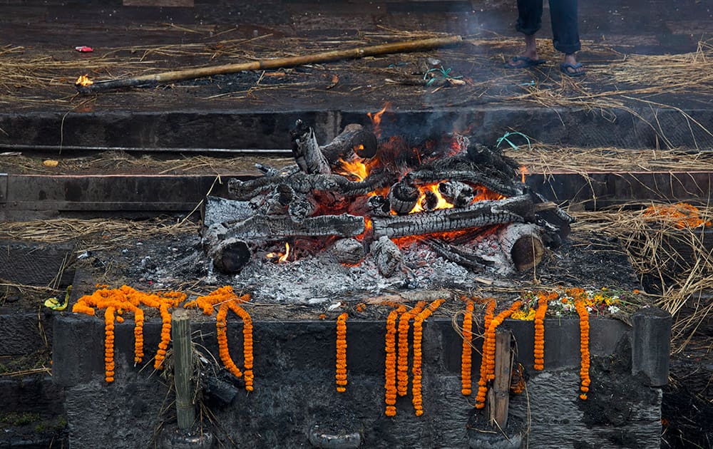 The last flames rise from a cremation pyre of a victim of Saturday's earthquake at the Pashupatinath temple on the banks of the Bagmati River in Kathmandu, Nepal.