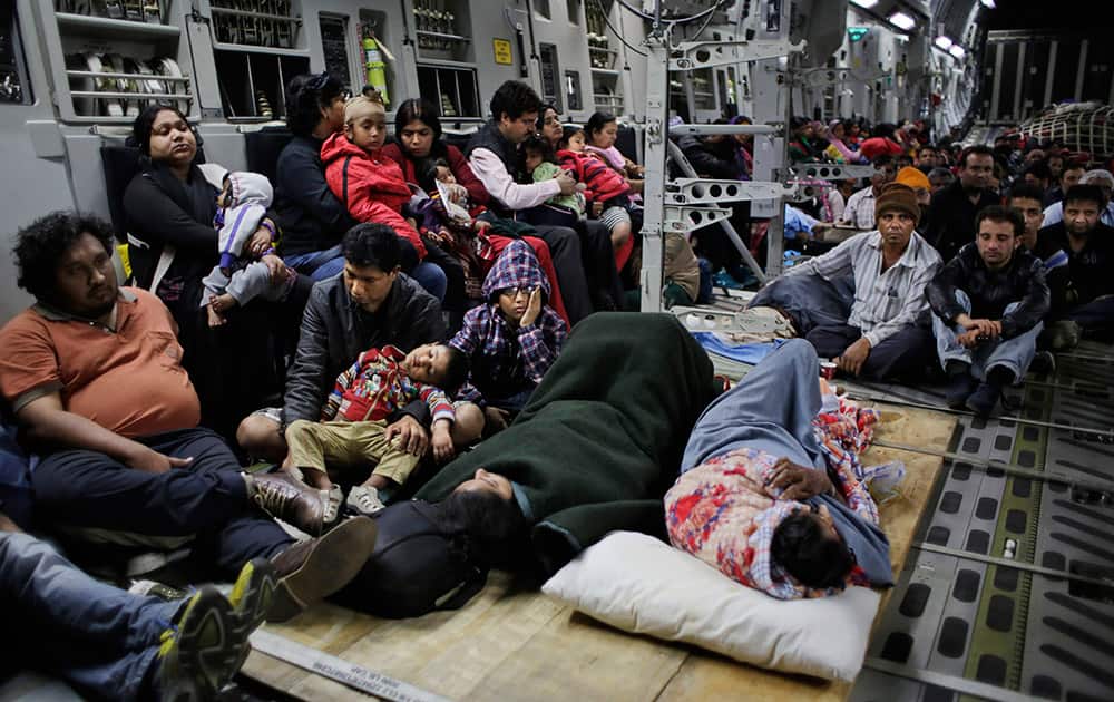 Injured people lie on the floor and survivors of Saturday's earthquake sit inside a military plane evacuating injured and stranded Indians from Kathmandu to New Delhi during a midnight rescue mission by Indian Air Force, in Kathmandu.