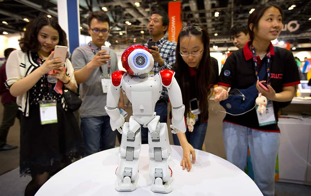 Visitors watch as a robot from Aldebaran Robotics dances at the Global Mobile Internet Conference in Beijing.