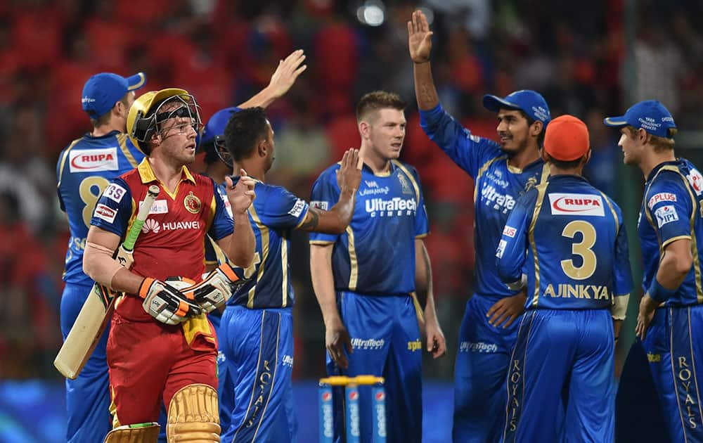  Royal Challengers Bangalores batsman AB De Villiers (L) leaves after his dismissal as Rajasthan Royals players celebrate during an IPL match in Bengaluru.