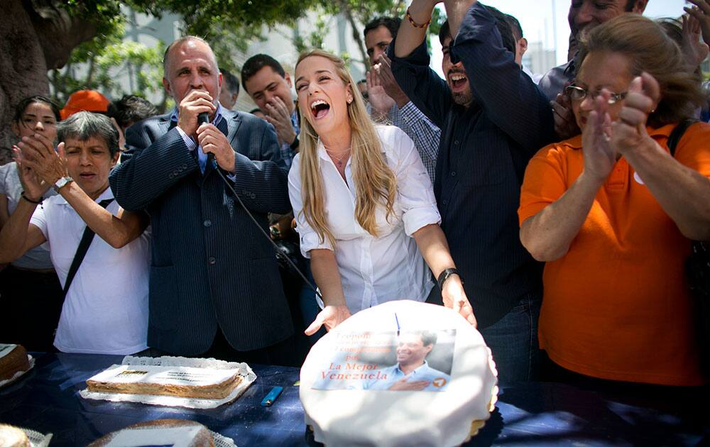 Lilian Tintori, the wife of jailed opposition leader Leopoldo Lopez, sings happy birthday to her husband and holds up a cake to celebrate his 44th birthday with supporters at Plaza Brion in Caracas Venezuela.
