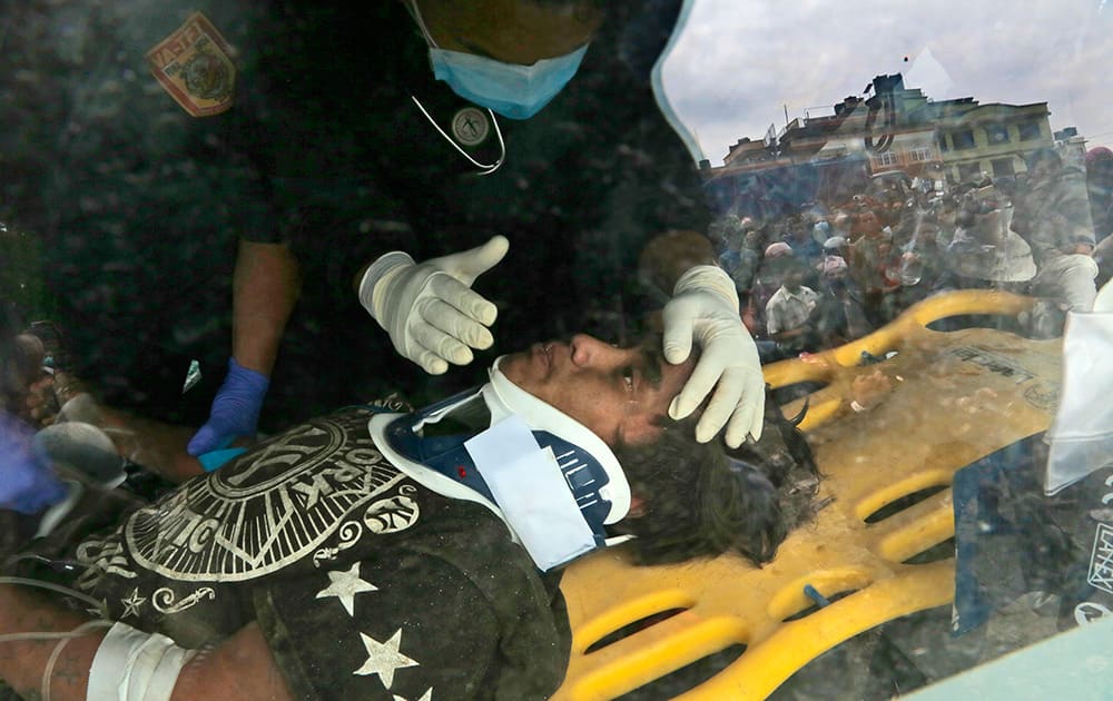 A US doctor attends to Pemba Tamang inside an ambulance after being rescued by Nepalese policemen and US rescue workers from a building that collapsed five days ago in Kathmandu, Nepal.