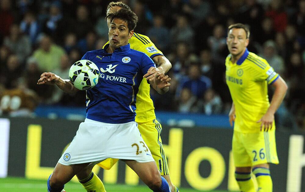 Leicester's Leonardo Ulloa, front, holds the ball from Chelsea's Nemanja Matic during the English Premier League soccer match between Leicester City and Chelsea at the King Power Stadium, Leicester, England.