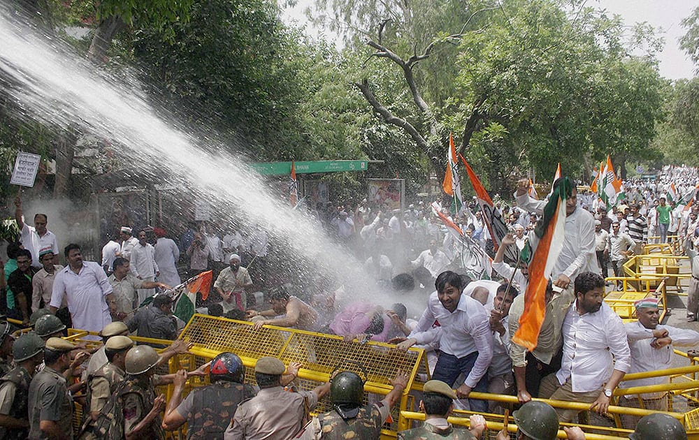 Congress workers brave water cannons at a protest against the Delhi government at ITO in New Delhi.