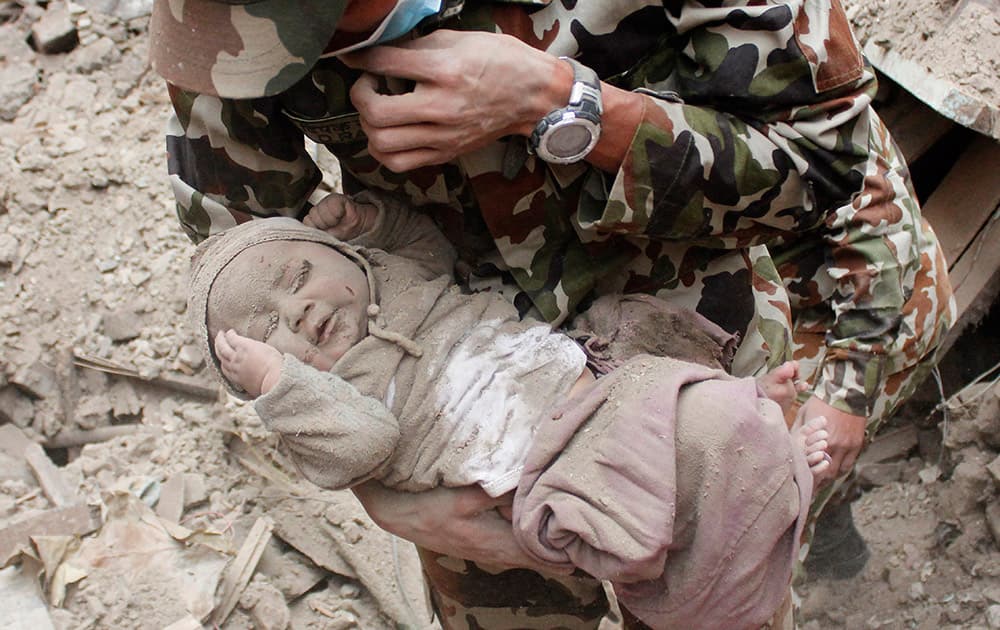 Four-month-old baby boy Sonit Awal is held up by Nepalese Army soldiers after being rescued from the rubble of his house in Bhaktapur, Nepal, after Saturday's 7.8-magnitude earthquake shook the densely populated Kathmandu valley.