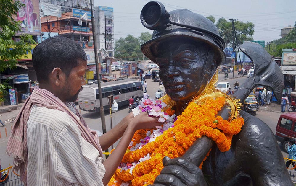 A labourer pays tribute to the statue of a Coal Miner on the occasion of May Day in Dhanbad.