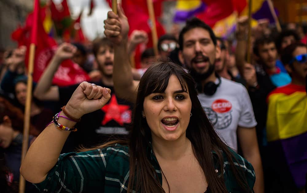 People shout slogans as they protest during a May Day rally in the center of Madrid, Spain.