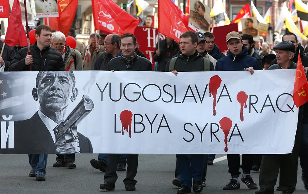 Communists carry a poster depicting US President Barack Obama during a traditional May Day march in St.Petersburg, Russia.