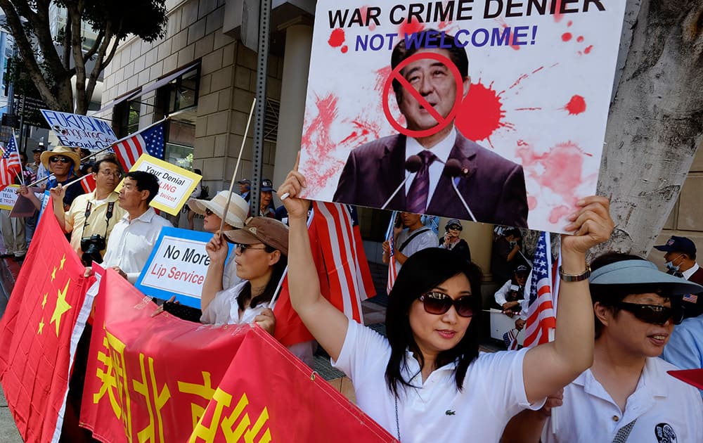 Demonstrators gather outside the Millennium Biltmore hotel in downtown Los Angeles during a visit by Japanese Prime Minister Shinzo Abe during a Japan-US Economic Forum.