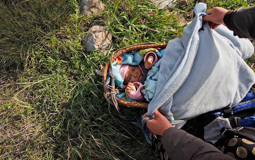 A Nepalese infant injured in Saturday’s earthquake is carried in a wicker basket after being evacuated from Melamchi in an Indian Air Force helicopter, in Kathmandu, Nepal.