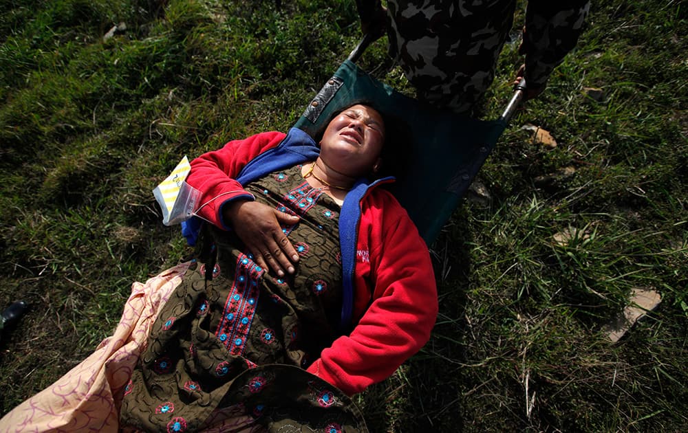 A woman, injured in Saturday’s earthquake, is carried on a stretcher after being evacuated from Melamchi in an Indian Air Force helicopter, at the airport in Kathmandu, Nepal.