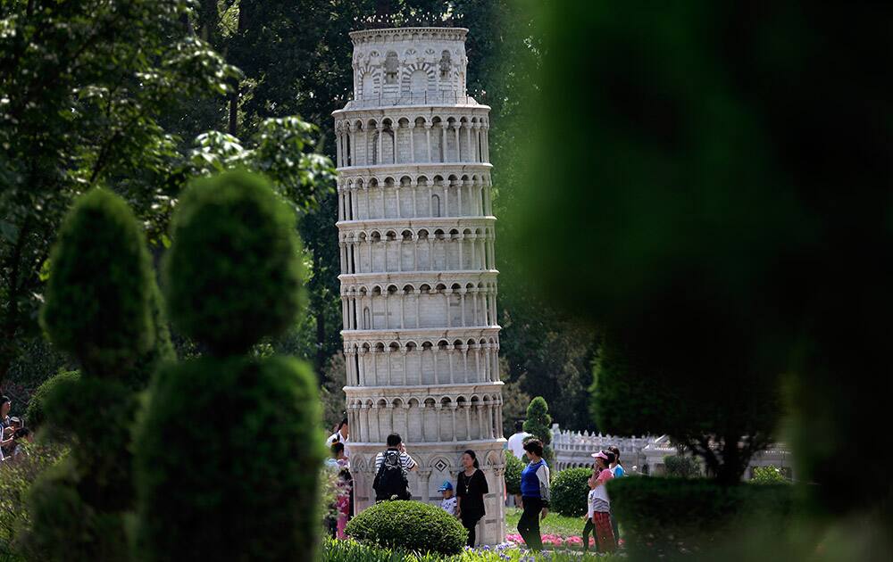 Visitors look at the replica of Italy's Leanig Tower of Pisa on display at the World Park in Beijing, China.