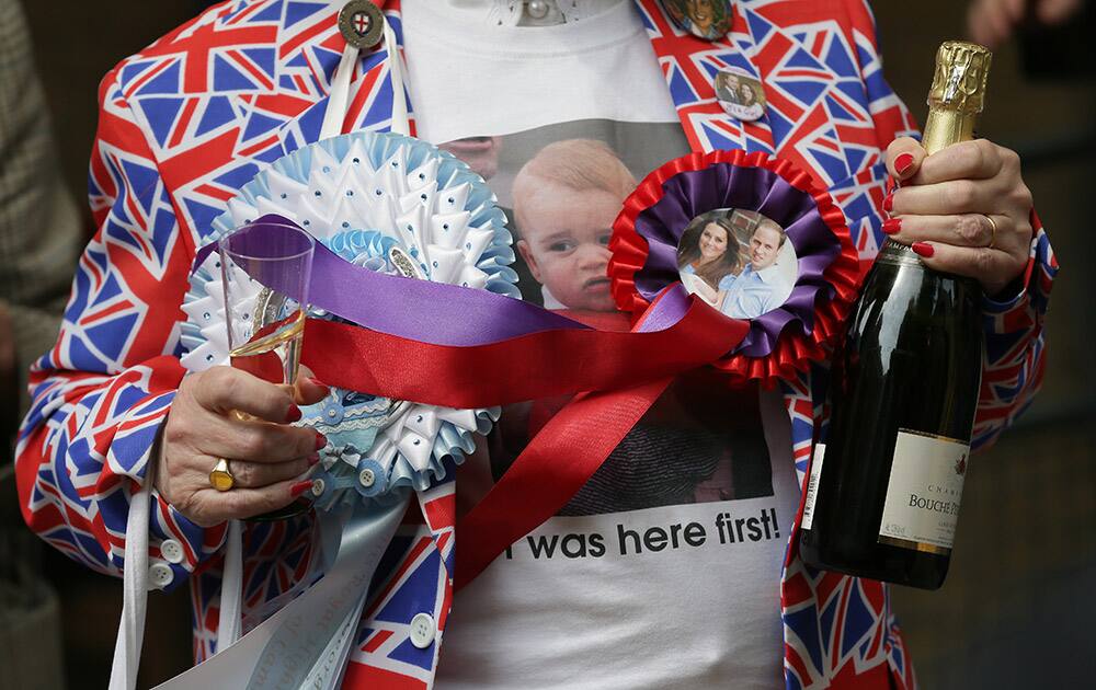 A wellwisher holds champagne to celebrate the birth of the royal baby, outside the Lindo Wing, St. Mary's Hospital, London. Kate, the Duchess of Cambridge, has given birth to a baby girl, royal officials said Saturday.