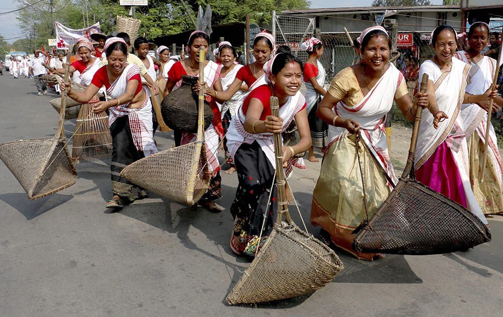 Women with traditional fishing equipments take part in a cultural procession on the occasion of Rongali Bihu Sammelan in Duliajan in Assam.