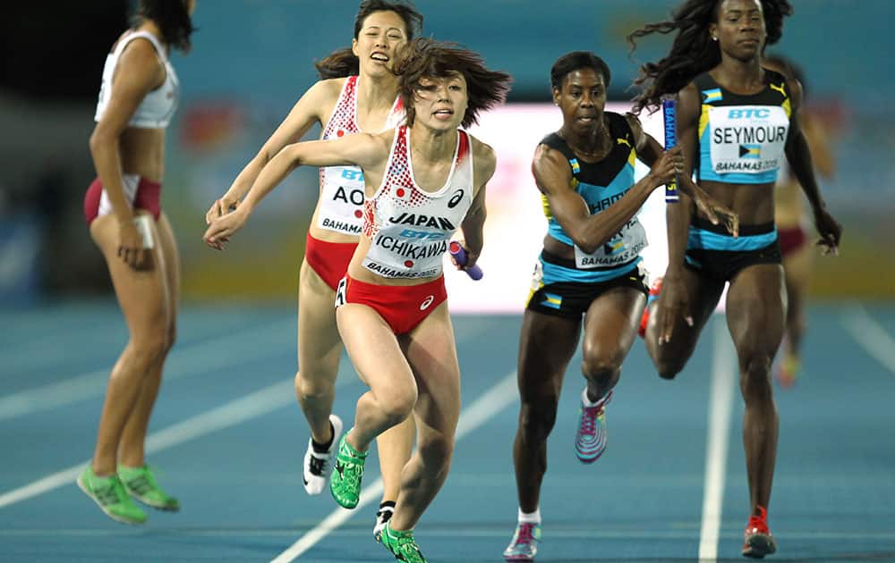 Kana Ichikawa takes the baton from Sayaka Aoki, back, in the Women's 4x400 meters heats at the World Relays in Nassau, Bahamas.