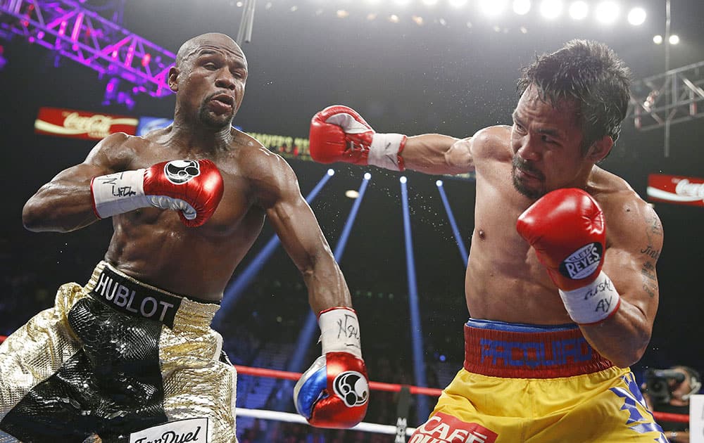 Manny Pacquiao, from the Philippines, right, throws a right against Floyd Mayweather Jr., during their welterweight title fight in Las Vegas. 
