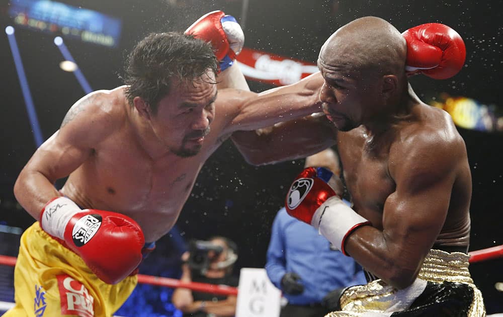 Manny Pacquiao, from the Philippines, left, trades blows with Floyd Mayweather Jr., during their welterweight title fight in Las Vegas. 