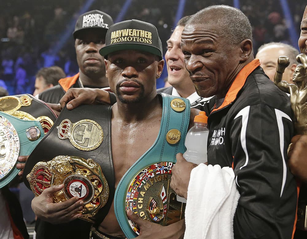 Floyd Mayweather Jr., left, poses with his champion's belts and his father, head trainer Floyd Mayweather Sr., after his victory over Manny Pacquiao, from the Philippines, in their welterweight title fight in Las Vegas. 